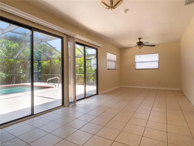 Spacious interior featuring tile flooring, multiple windows, and a ceiling fan