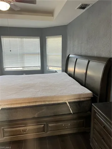 Unfurnished bedroom featuring dark wood-type flooring and ceiling fan