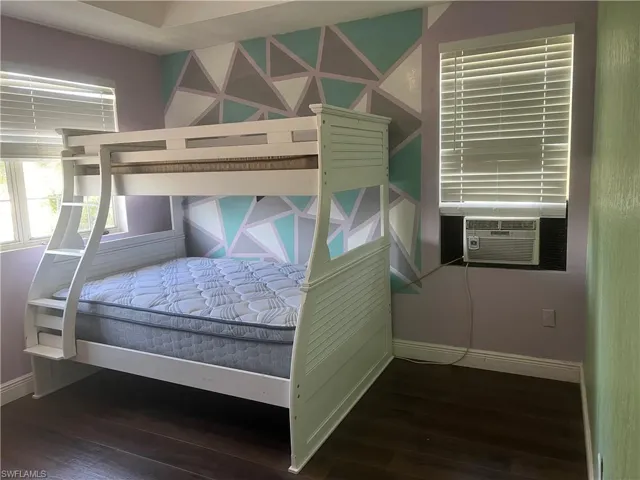Bedroom with dark wood-type flooring and cooling unit