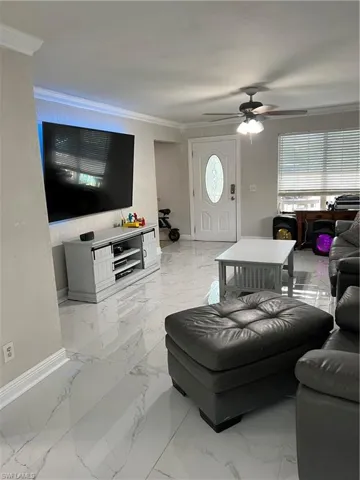 Living room with ornamental molding and plenty of natural light