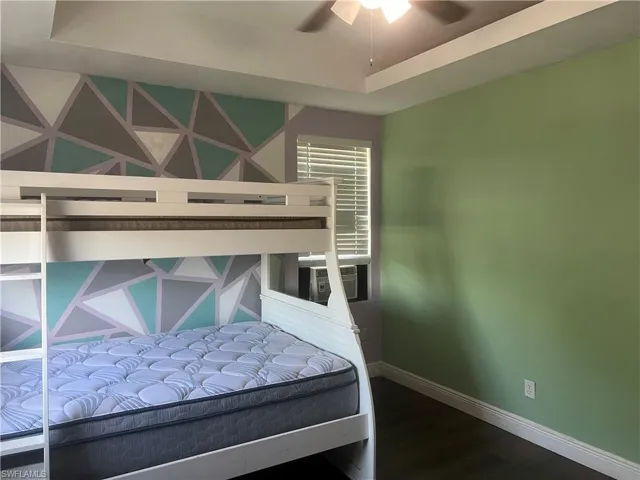Bedroom with cooling unit, hardwood / wood-style flooring, and ceiling fan