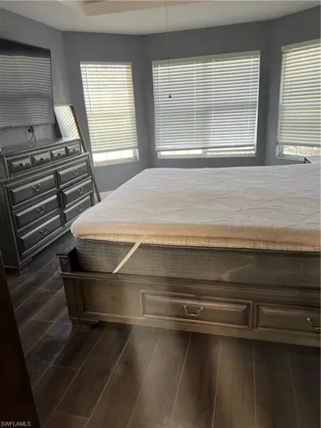 Bedroom with dark hardwood / wood-style flooring
