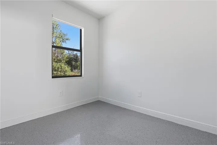 Unfurnished room featuring baseboards and speckle patterned floor