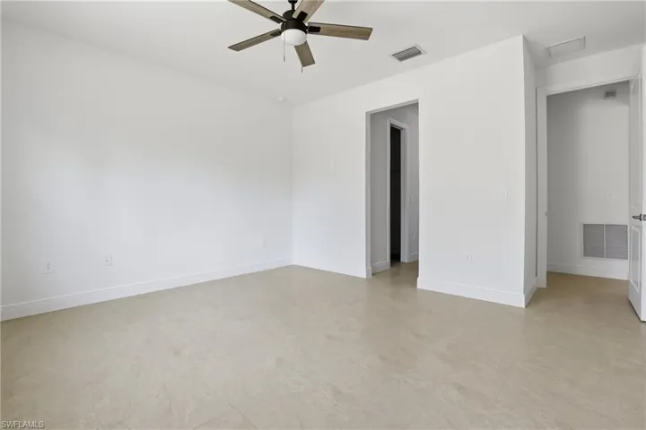 Empty room featuring ceiling fan and baseboards