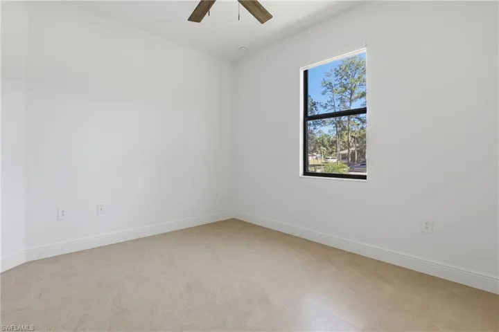 Unfurnished room featuring baseboards and ceiling fan