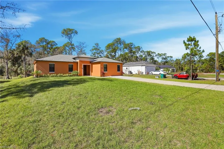 View of front of home with a front yard, stucco siding, and driveway