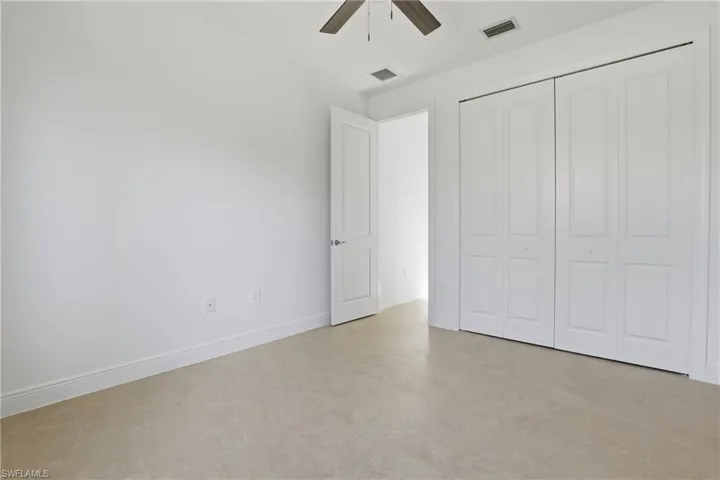 Unfurnished bedroom with a ceiling fan and a closet