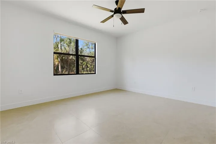 Unfurnished room featuring ceiling fan and baseboards