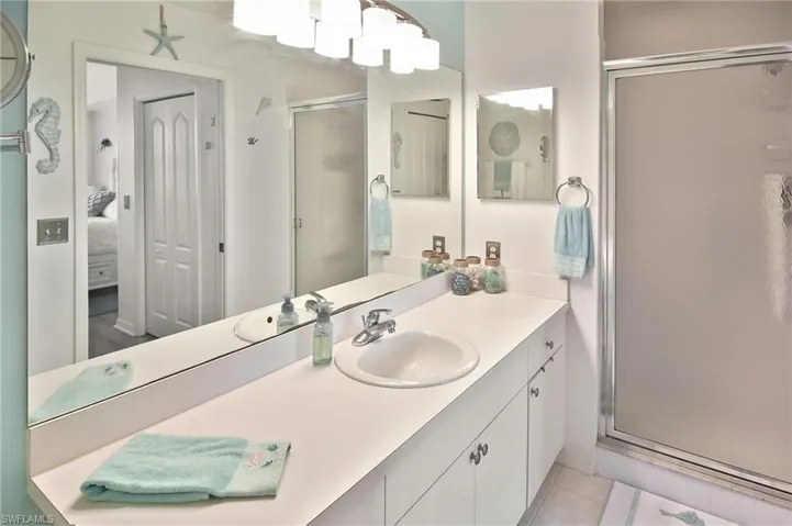 Bathroom with a stall shower, vanity, ensuite bath, and light tile patterned flooring