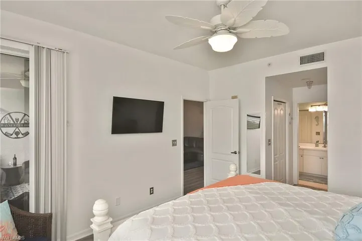 Bedroom featuring ensuite bathroom and a ceiling fan