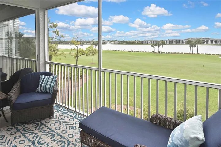 Sunroom with view of golf course and a water view