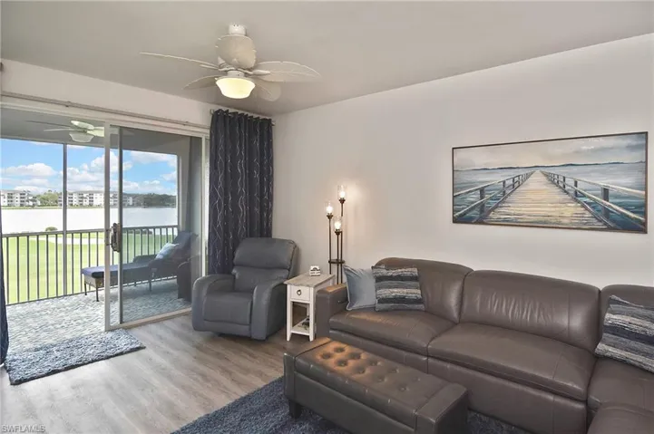 Living area featuring a water view, a ceiling fan, and wood finished floors