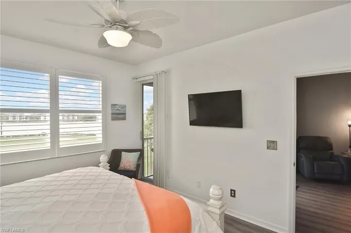 Bedroom featuring access to exterior, a ceiling fan, and dark wood-type flooring