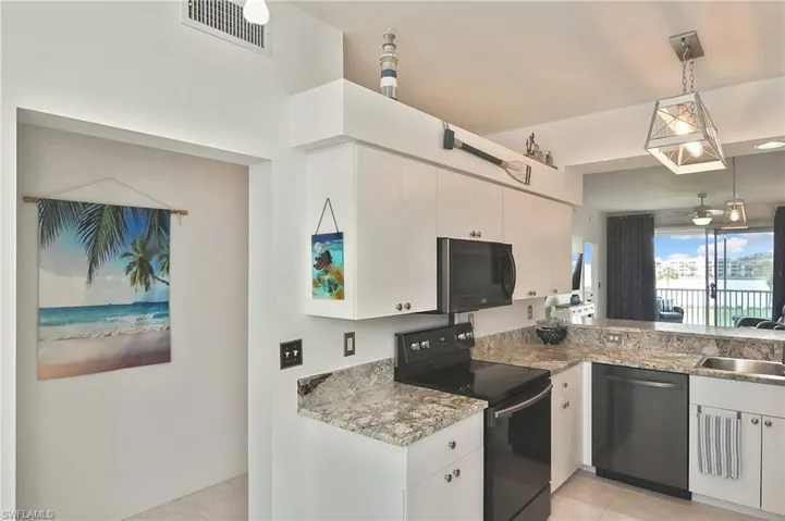 Kitchen with black range with electric cooktop, stainless steel dishwasher, white cabinetry, pendant lighting, and light tile patterned floors