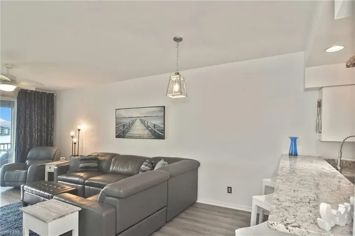 Living room with dark wood-style floors, a ceiling fan, and recessed lighting