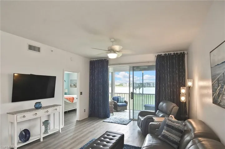Living area featuring wood finished floors, a water view, and ceiling fan