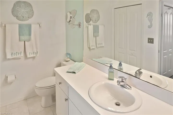 Bathroom featuring vanity, light tile patterned floors, and a closet