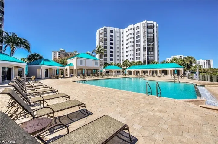 Pool has a lot of chairs for sun and shade