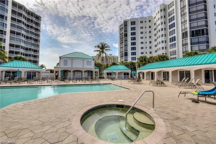 View of swimming pool with a hot tub