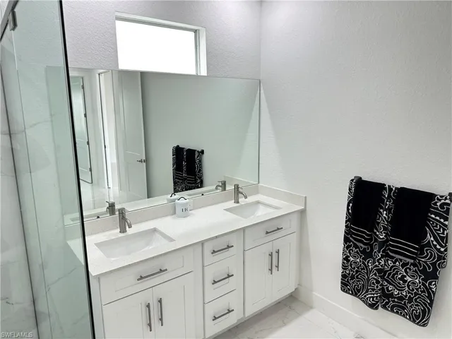Dual vanity with under-mount sinks, quartz countertop, and brushed nickel faucets