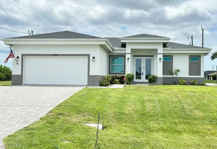 Contemporary single-story residence with a white and grey exterior, featuring a double-door entry