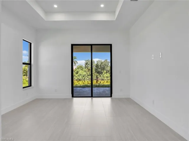 Unfurnished room with a raised ceiling and recessed lighting