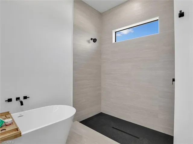 Bathroom with a soaking tub and a tile shower