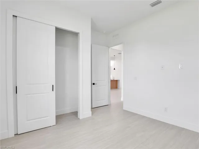 Unfurnished bedroom featuring light wood-style floors and a closet