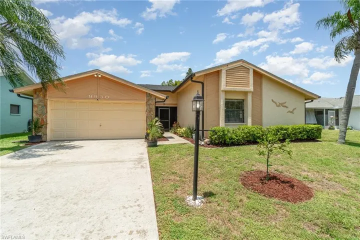 Single story home with a garage and a front lawn