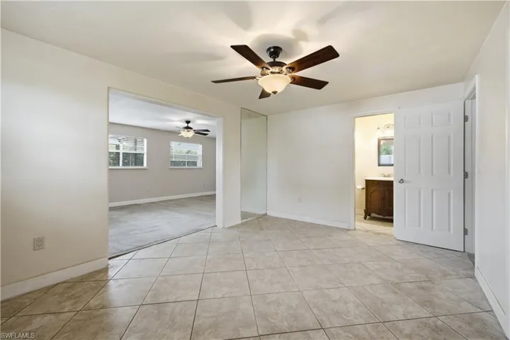 Spacious room featuring neutral tile flooring and a ceiling fan with integrated lighting