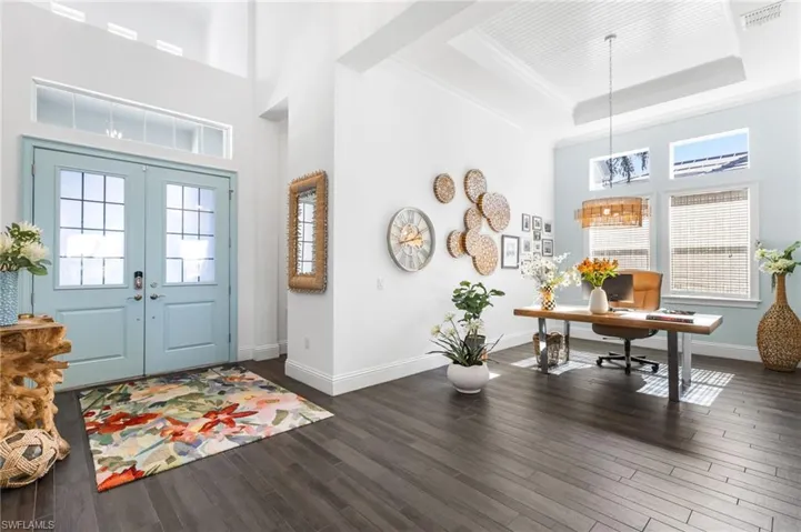 Entrance foyer with a high ceiling, french doors, ornamental molding, a tray ceiling, and dark hardwood / wood-style flooring