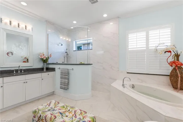 Bathroom featuring vanity, independent shower and bath, and crown molding