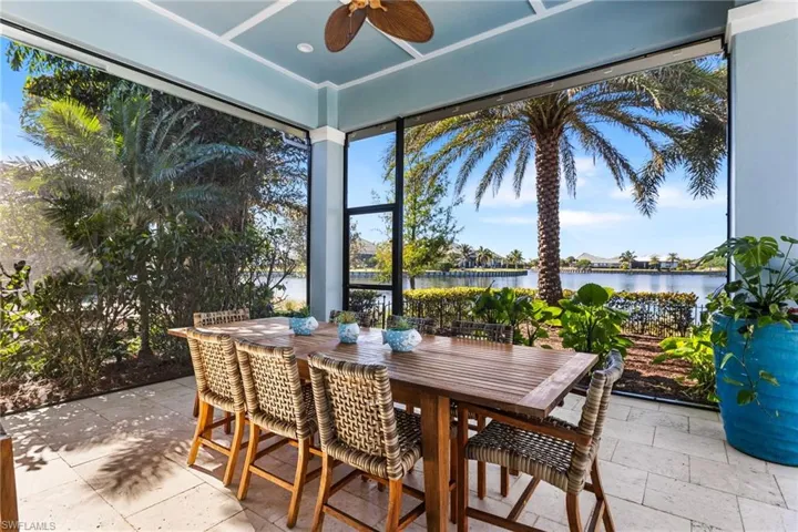 Sunroom with ceiling fan and a water view