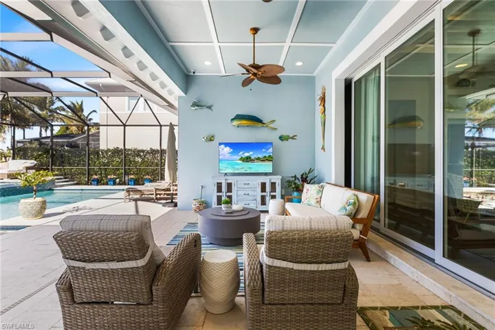 View of patio featuring ceiling fan and a lanai