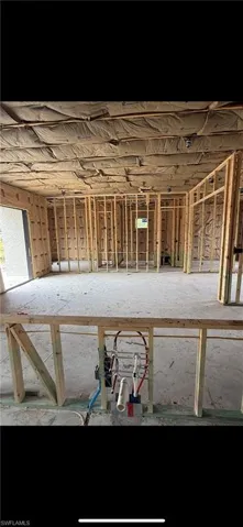 Framed wood structure featuring exposed wall and ceiling studs, overhead insulation, and installed plumbing rough-ins