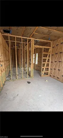 Interior space featuring exposed wood-stud wall framing, insulated wall panels, and a concrete subfloor