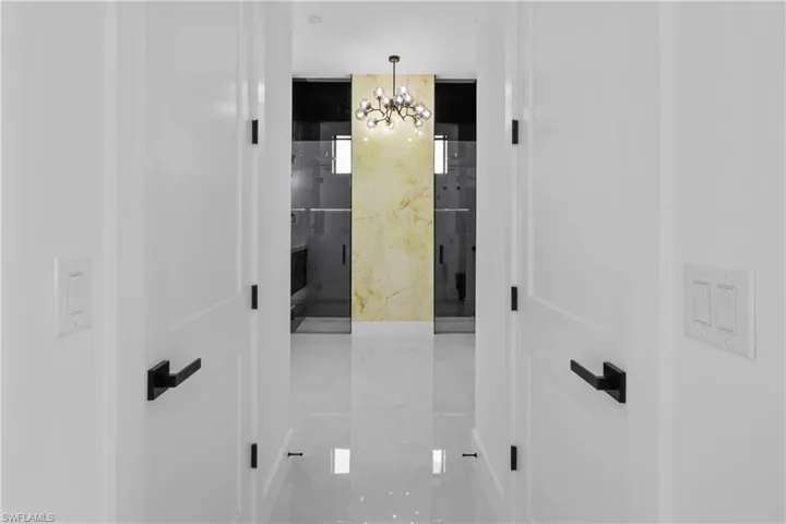 Hall featuring a chandelier and light tile patterned floors