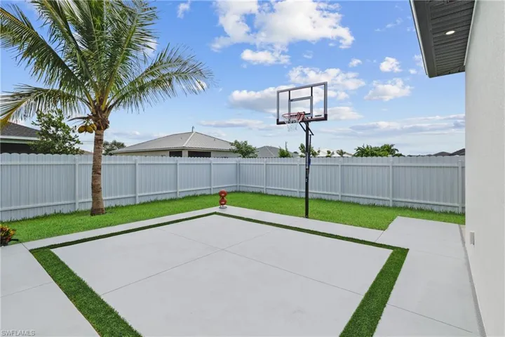 View of basketball court with a fenced backyard, a patio, and basketball hoop