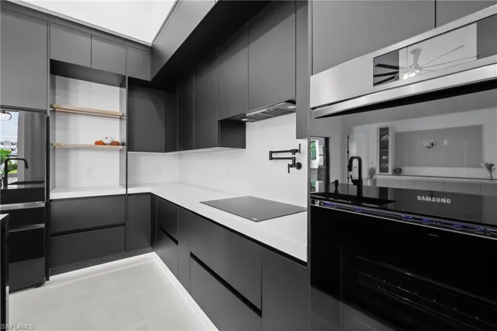 Kitchen featuring modern cabinets, open shelves, and dark cabinets