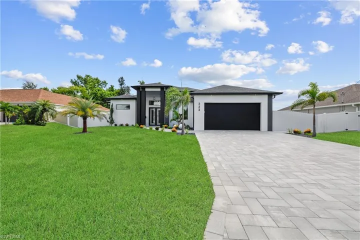 Prairie-style house featuring decorative driveway, an attached garage, and stucco siding