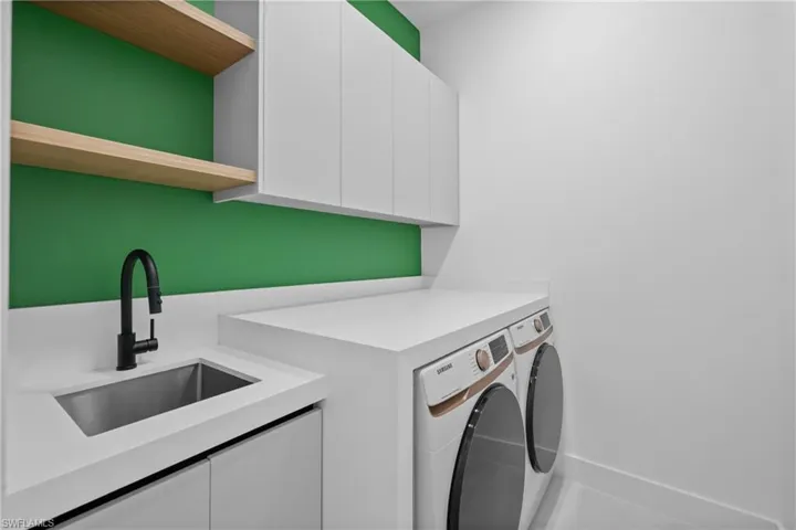 Laundry area featuring cabinet space and washer and clothes dryer