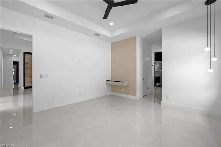 Spare room featuring a tray ceiling, recessed lighting, and a ceiling fan