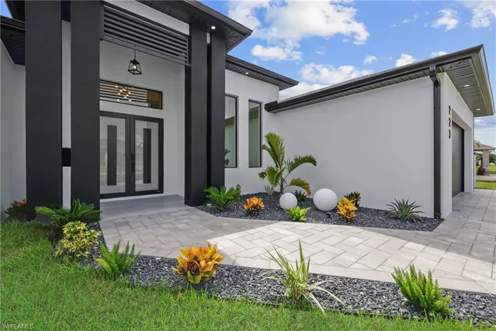 View of exterior entry featuring stucco siding and french doors