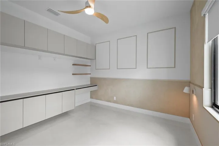 Unfurnished office featuring baseboards and a ceiling fan