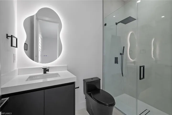 Bathroom with vanity and a marble finish shower