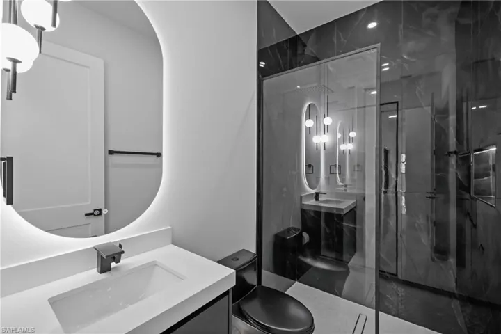 Full bathroom featuring a marble finish shower and vanity