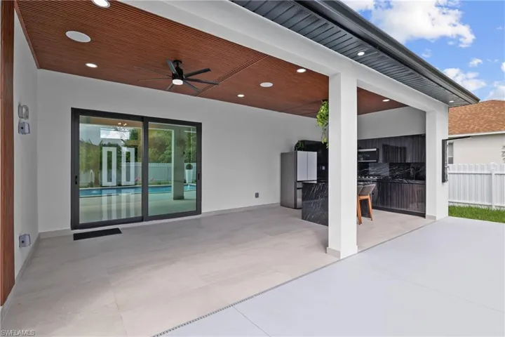 View of patio with ceiling fan and area for grilling