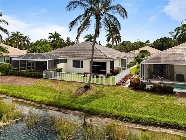Back of property with a lanai, a water view, and stucco siding
