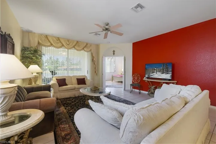Living room featuring light tile patterned floors, ceiling fan, and recessed lighting