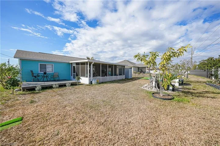 Back of house featuring a sunroom and a wooden deck
